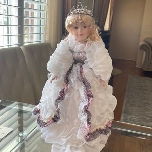 Beautiful blonde porcelain doll, has two accessories, a crown and a white hat!
